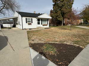 View of front of home featuring a porch, a carport, and a front lawn