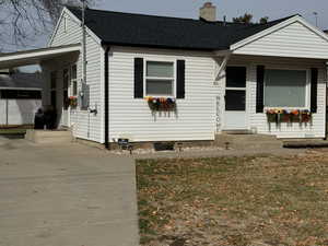 View of front of home featuring a front lawn and a carport