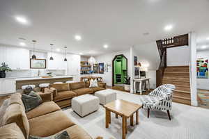 Living room featuring light wood-type flooring and a notable chandelier