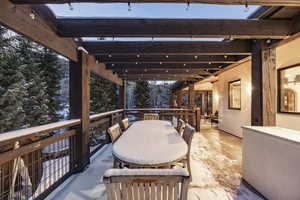 Snow covered patio featuring a pergola