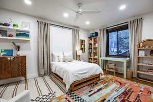 Bedroom featuring hardwood / wood-style flooring, ceiling fan, and multiple windows