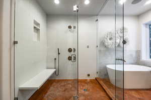 Bathroom featuring separate shower and tub, tile patterned floors, and tile walls