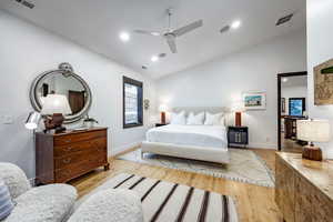 Bedroom featuring ceiling fan, lofted ceiling, and light wood-type flooring