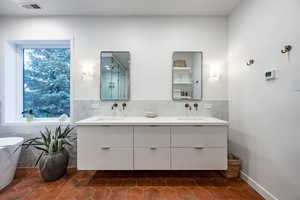 Bathroom with tile patterned flooring, vanity, and a tub