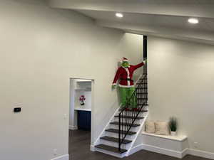 Stairs with hardwood / wood-style floors, beam ceiling, and wooden ceiling