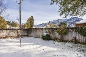 Yard layered in snow with a mountain view