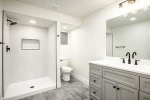 Bathroom featuring vanity, toilet, walk in shower, and electric panel