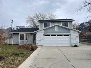 View of front facade with a mountain view, a garage, and a front yard