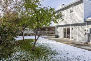 Yard covered in snow with a patio and central air condition unit