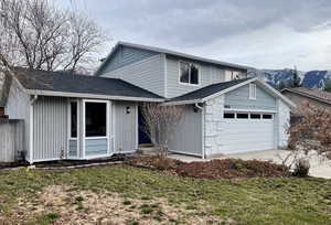 View of front of home with a mountain view and a garage