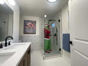 Bathroom with tile patterned floors, vanity, tile walls, and walk in shower