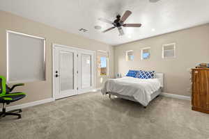 Carpeted bedroom featuring a textured ceiling and ceiling fan