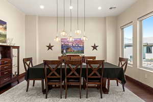 Dining room with wood-type flooring and an inviting chandelier