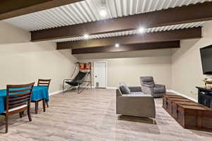 Living room featuring beamed ceiling and light hardwood / wood-style flooring