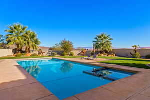 View of swimming pool with a yard and a patio