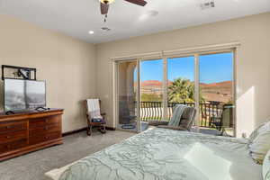 Bedroom with access to outside, light carpet, ceiling fan, and a mountain view