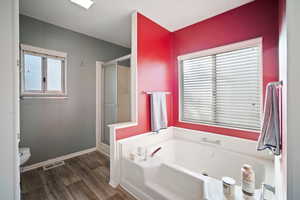 Bathroom with laminate flooring, toilet, and independent shower and bath