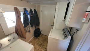 Washroom with cabinets, water heater, and washer and dryer