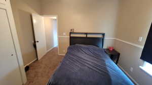 Carpeted bedroom with a closet