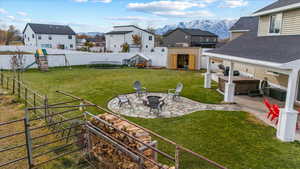 View of yard with an outdoor fire pit, a playground, a mountain view, and a patio area