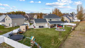 Rear view of property featuring a storage shed, a fire pit, a patio area,  and a playground