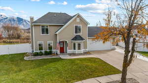 Front of property featuring a mountain view, a garage, and a front yard