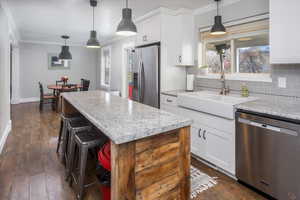 Kitchen with white cabinetry, a center island, and stainless steel appliances