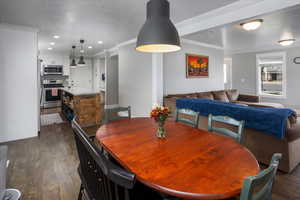 Dining area with dark wood-type flooring and ornamental molding