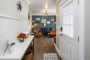 Entryway featuring dark hardwood / wood-style flooring and ornamental molding