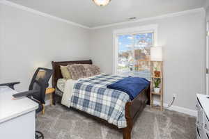 Carpeted bedroom featuring ornamental molding