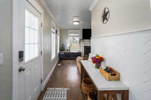 Doorway to outside with dark hardwood / wood-style floors and a tiled fireplace