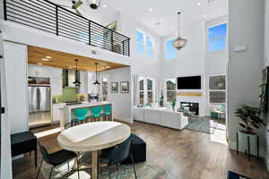 Dining room with a high ceiling, a large fireplace, and dark hardwood / wood-style floors