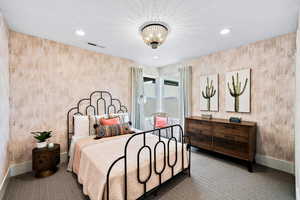 Bedroom with carpet and a textured ceiling