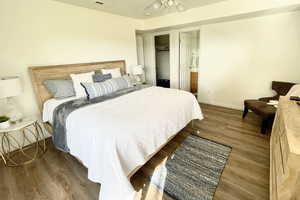 Bedroom featuring a closet, ceiling fan, ensuite bathroom, and dark LVP flooring