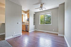 Unfurnished living room with ceiling fan and hardwood / wood-style floors