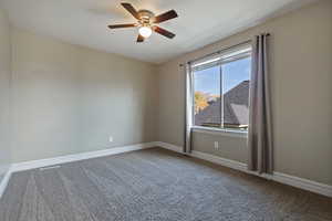 Carpeted spare room with ceiling fan