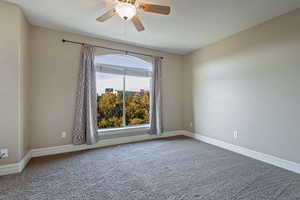 Spare room with ceiling fan and carpet floors