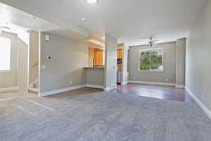 Unfurnished living room with ceiling fan and wood-type flooring