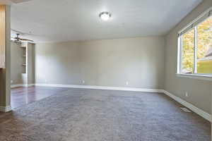 Unfurnished room featuring built in shelves, hardwood / wood-style flooring, and ceiling fan