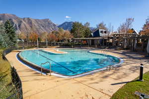 View of pool with a pergola, a mountain view, and a patio