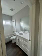 Example Full bathroom with wood-style floors, vanity, shower / tub combination, and toilet