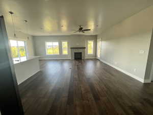 Example Unfurnished living room featuring dark wood-type flooring, a fireplace, and ceiling fan