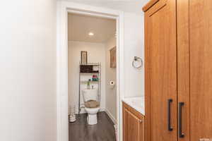 Bathroom with toilet, vanity, and hardwood / wood-style flooring