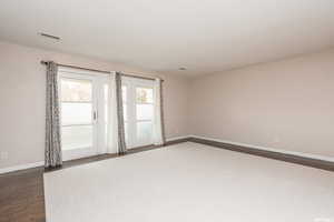 Unfurnished room with dark wood-type flooring