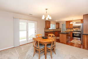 Dining room with light wood-type flooring, sink, and a chandelier