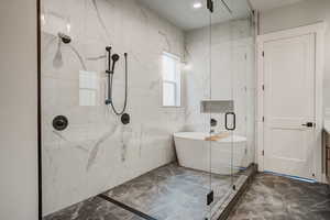 Bathroom featuring vanity, plus walk in shower, and tile walls