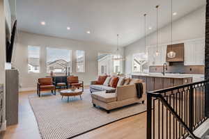 Living room with light hardwood / wood-style floors and high vaulted ceiling