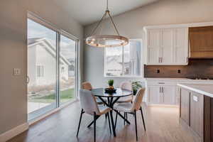 Dining space with light wood-type flooring, a wealth of natural light, and lofted ceiling