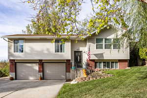 Split foyer home with a front lawn and a garage