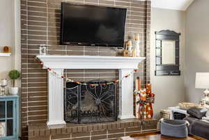 Details featuring hardwood / wood-style floors and a brick fireplace